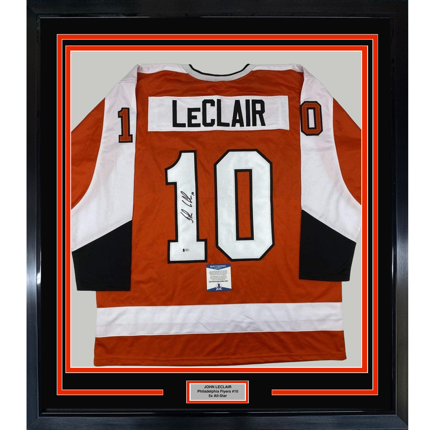Framed orange Philadelphia Flyers jersey number 10 with "LeClair" nameplate and autographed signature, displayed flat against white matting with red border frame.