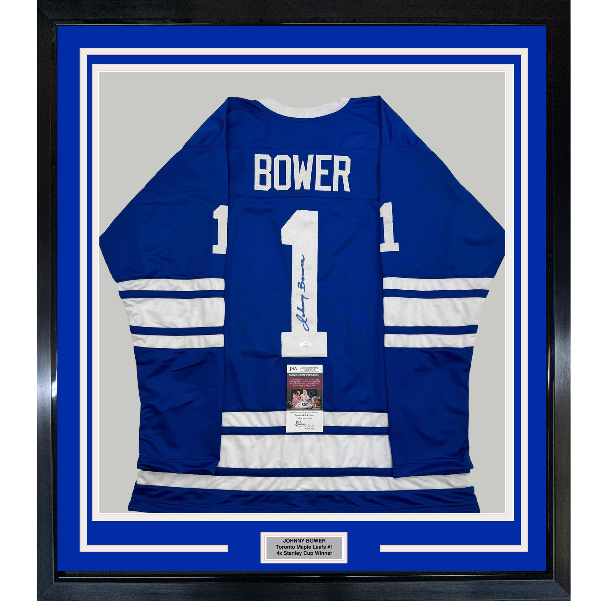 Framed blue and white Toronto Maple Leafs #1 hockey jersey signed by Johnny Bower, displayed flat against gray backing with authentication certificate visible.