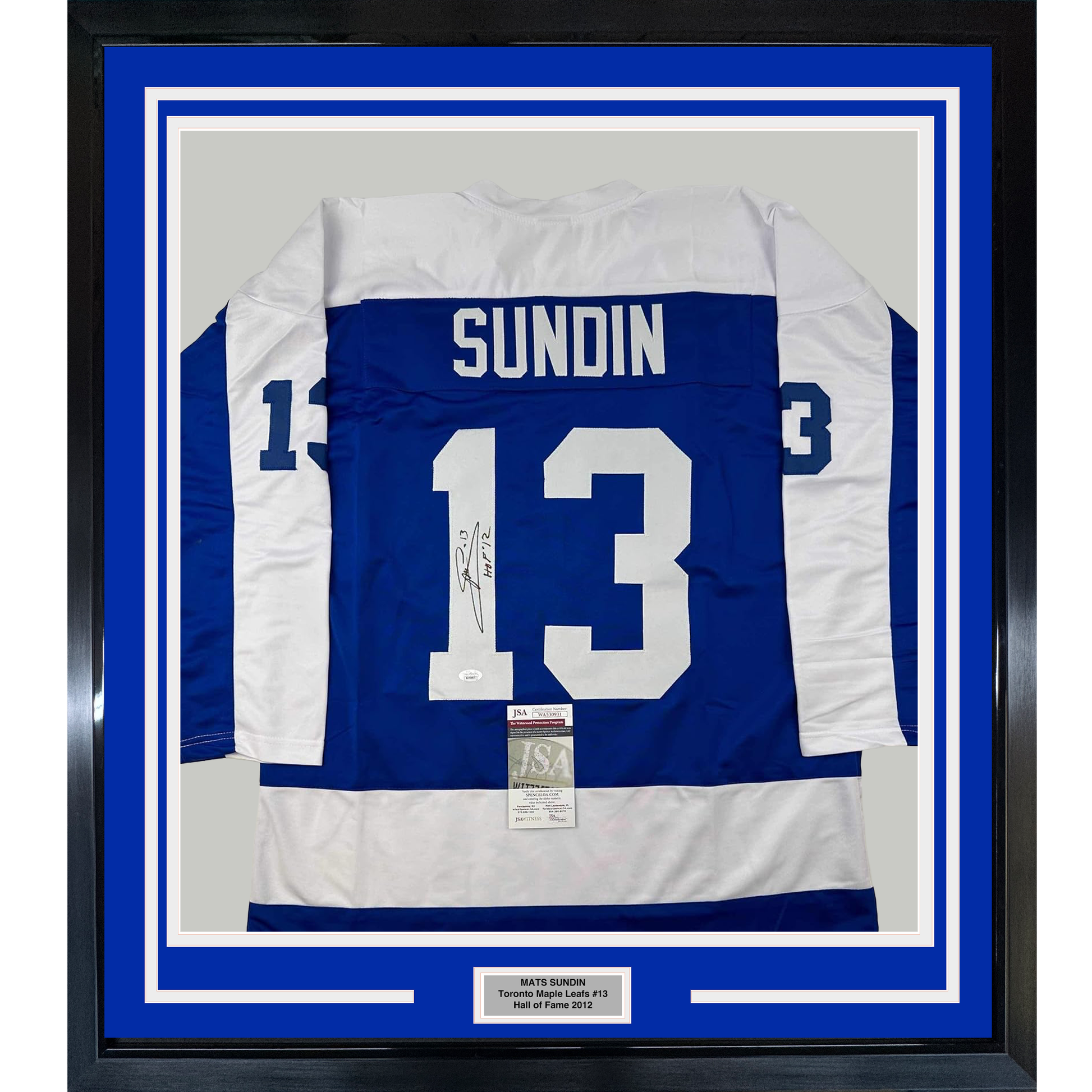 Framed Toronto Maple Leafs blue and white hockey jersey number 13 with "SUNDIN" nameplate and autographed signature, mounted with JSA authentication certificate and nameplate on blue matting.