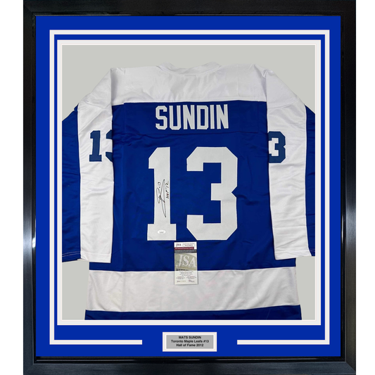 Framed Toronto Maple Leafs blue and white hockey jersey number 13 with "SUNDIN" nameplate and autographed signature, mounted with JSA authentication certificate and nameplate on blue matting.