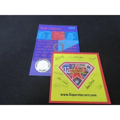 Two signed sports memorabilia pieces, purple and yellow, with certification marks and signatures, related to Karl Malone Autograph SKYBOX Basketball Card Collectible