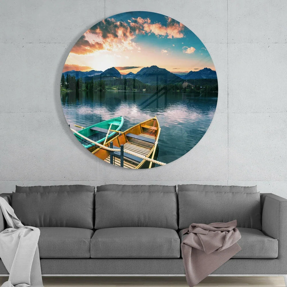 Circular tempered glass art of sunset over mountains with rowboats at dock