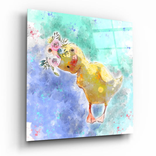 Yellow duckling holding pink flowers against a watercolor background of mint green and blue splashes on glass wall art.