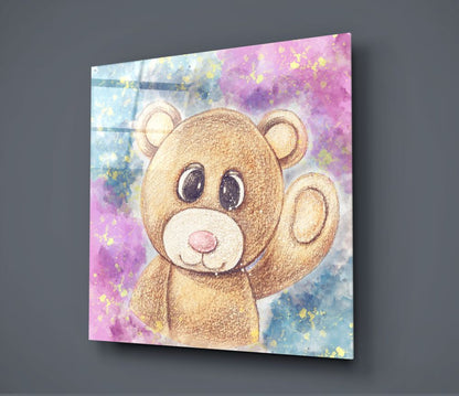 Teddy Bear Glass Wall Art displayed at an angle showing a brown bear illustration with watercolor pink and blue background splashes and gold accents.