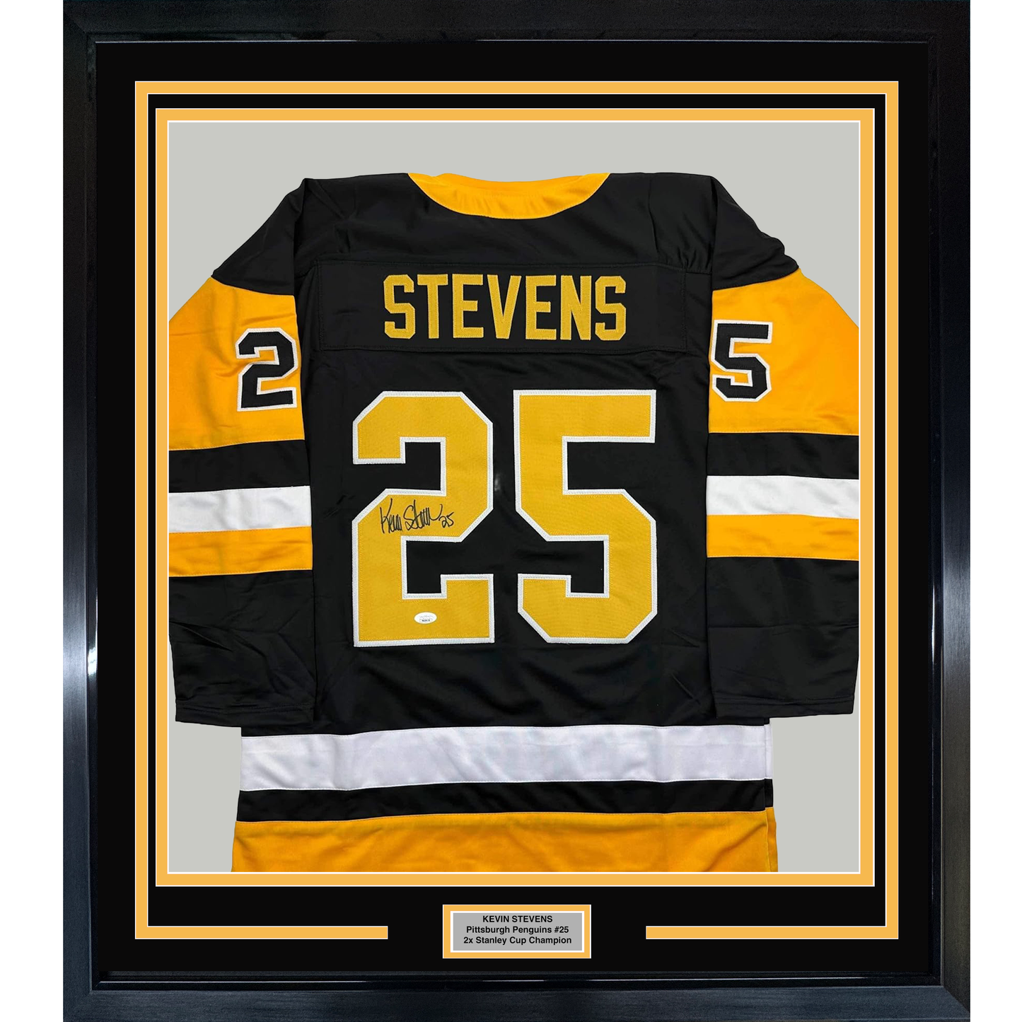 Framed black Pittsburgh Penguins hockey jersey #25 with yellow and white stripes, signed by Kevin Stevens, displayed front-facing with nameplate below.