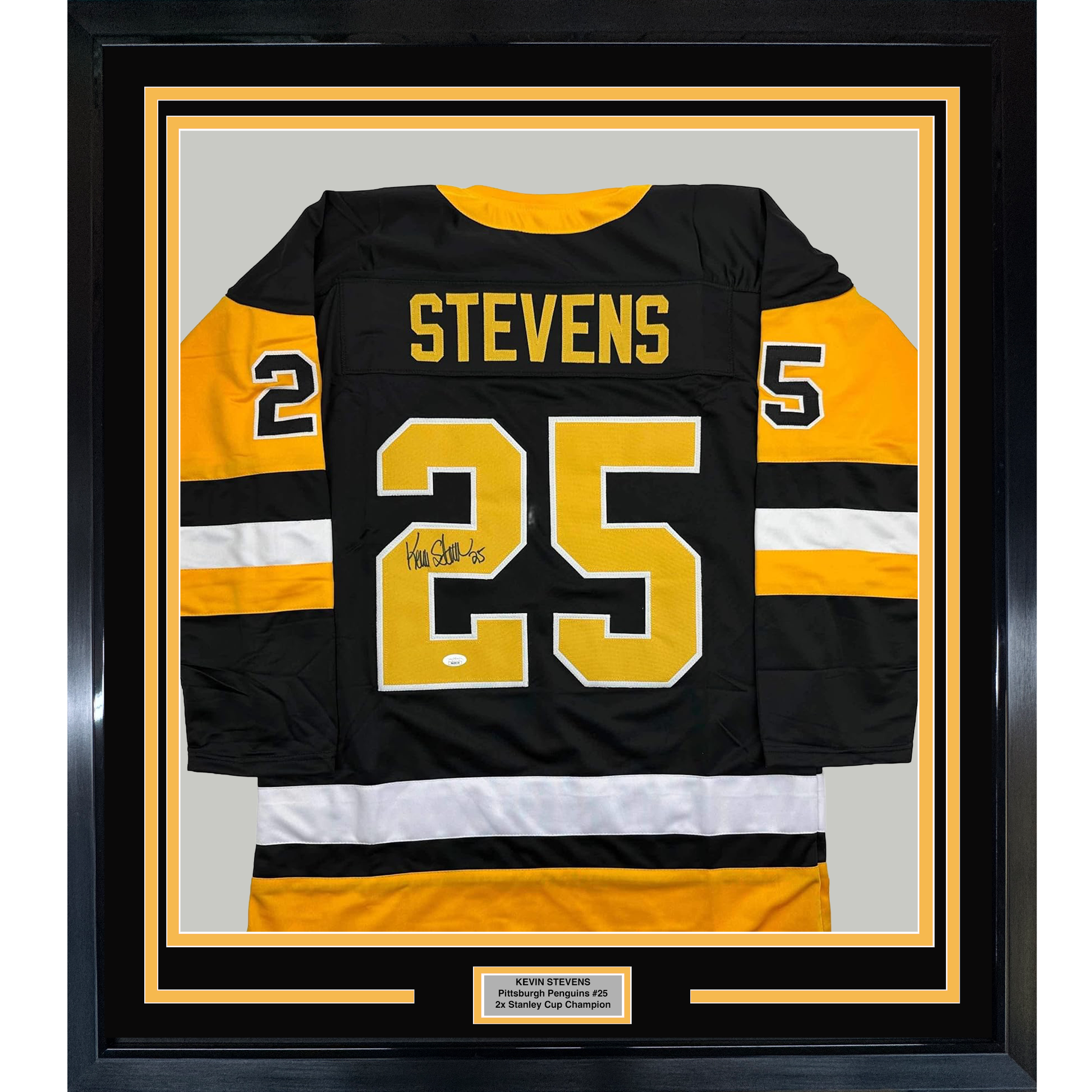 Framed black Pittsburgh Penguins hockey jersey #25 with yellow and white stripes, signed by Kevin Stevens, displayed front-facing with nameplate below.