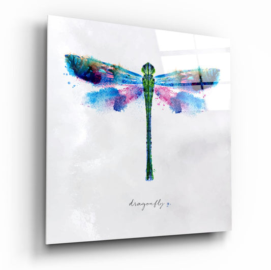 Watercolor dragonfly glass wall art with vibrant blue, pink, and green splattered wings and green body on white background, with "dragonfly" text below.