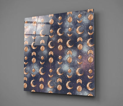 Angled perspective of glass wall art featuring copper moon phases and spheres suspended on strings against a dark starry night sky background.