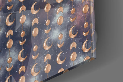 Close-up angle of glass panel displaying copper moon phases and stars on dark blue night sky background.