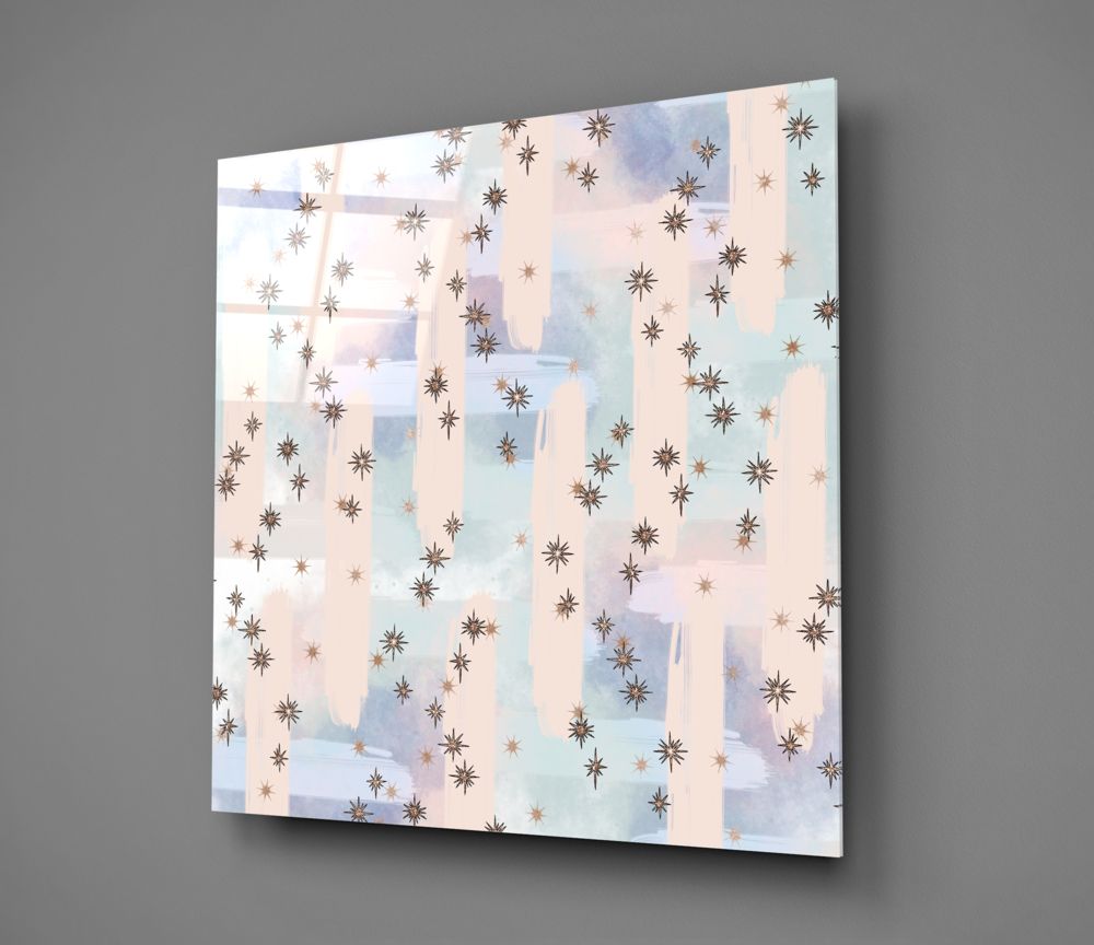 Angled view of glass wall art displaying watercolor washes in pastel blues, pinks, and creams with scattered brown and gold star patterns.