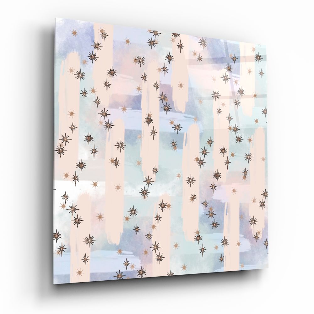 Angled perspective of glass wall art featuring brown and copper stars scattered across soft watercolor washes in cream, blue, and lavender.