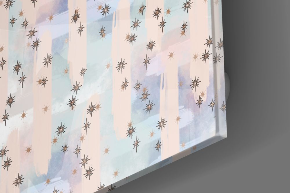 Angled view of glass wall art featuring scattered bronze and copper stars on soft pastel stripes in cream, blue, and lavender.