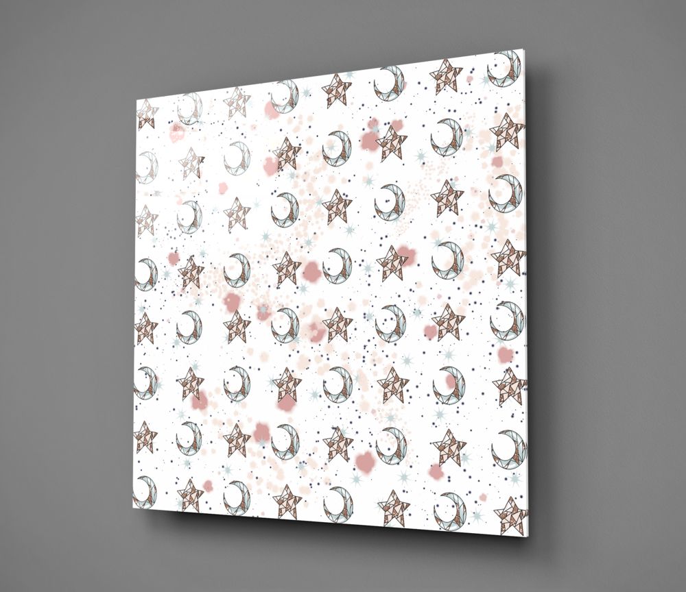 Square glass wall art panel displayed at an angle showing repeating pattern of bronze stars, crescent moons, and pink watercolor splashes on white background.