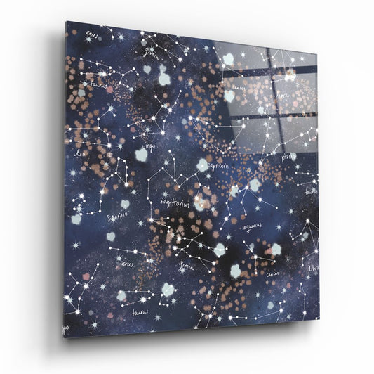 Glass constellation wall art displayed at an angle showing zodiac names, white star patterns, and bronze and cream bokeh circles on dark blue background.
