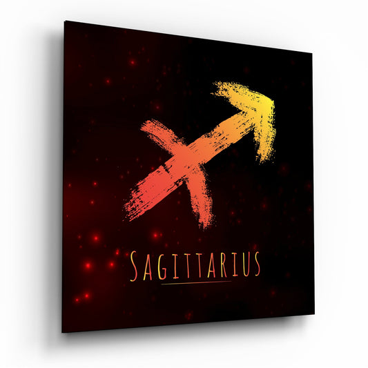 Angled view of glass wall art displaying a red and yellow arrow symbol with "SAGITTARIUS" text on dark background with red light particles.