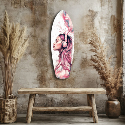Elongated oval glass wall art featuring a pink-haired woman with headphones in profile, displayed above a wooden bench flanked by dried grasses.