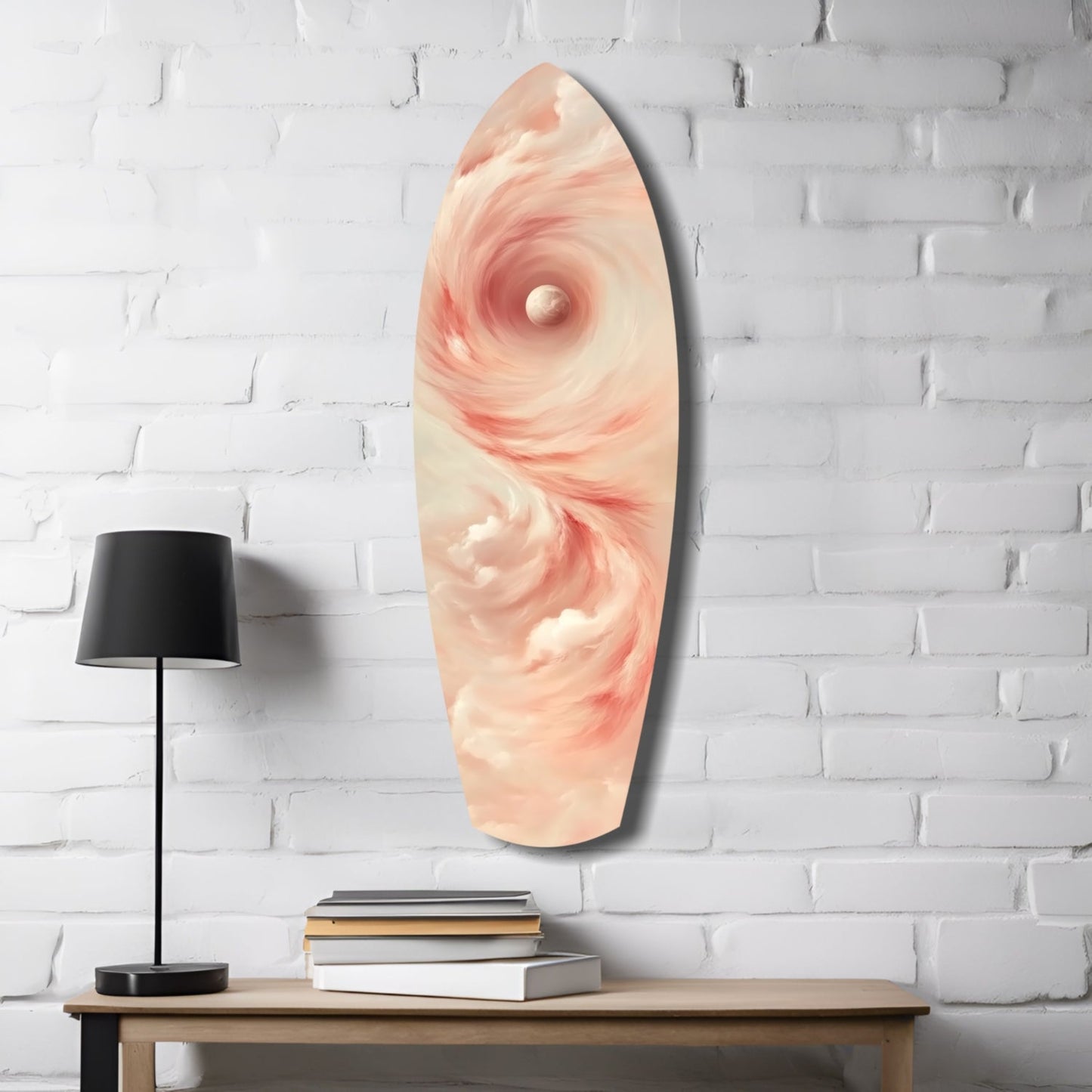 Pinky Swirl glass wall art displayed on white brick wall above wooden table with black lamp and stacked books.