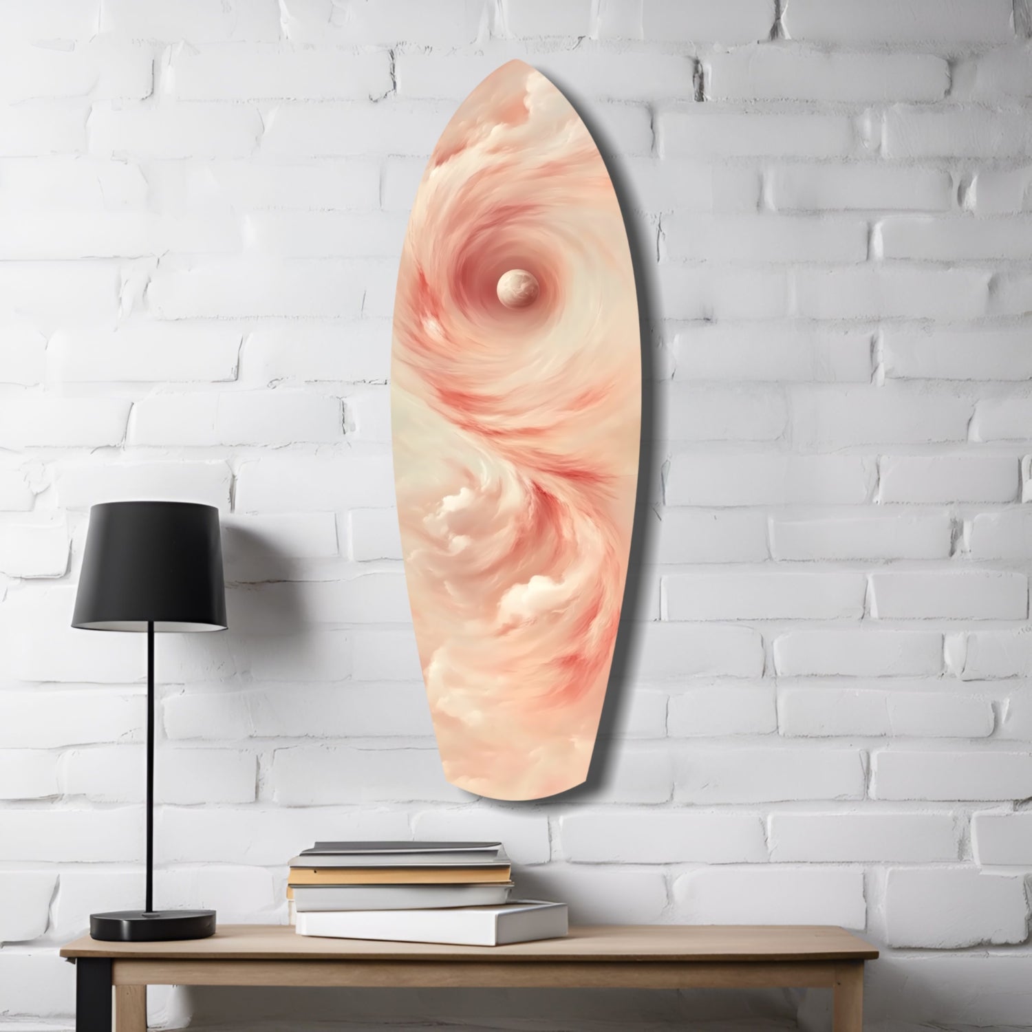 Pinky Swirl glass wall art displayed on white brick wall above wooden table with black lamp and stacked books.
