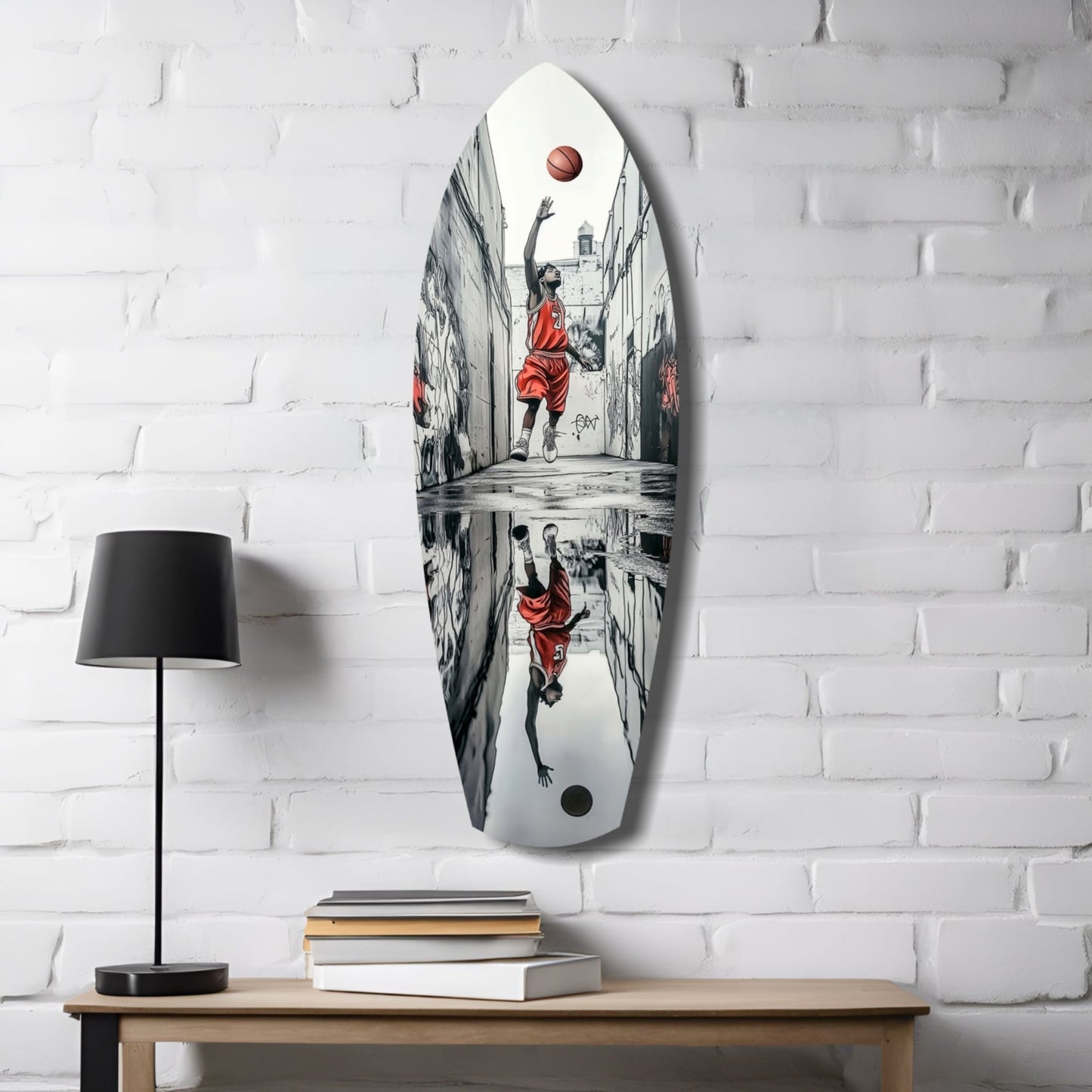 White oval glass wall art displaying street basketball player in red jersey shooting ball, mounted above wooden desk with lamp and books.