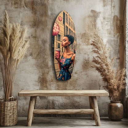 Modern glass wall art featuring a woman in blue holding a red object against a yellow building backdrop, displayed above a wooden bench.