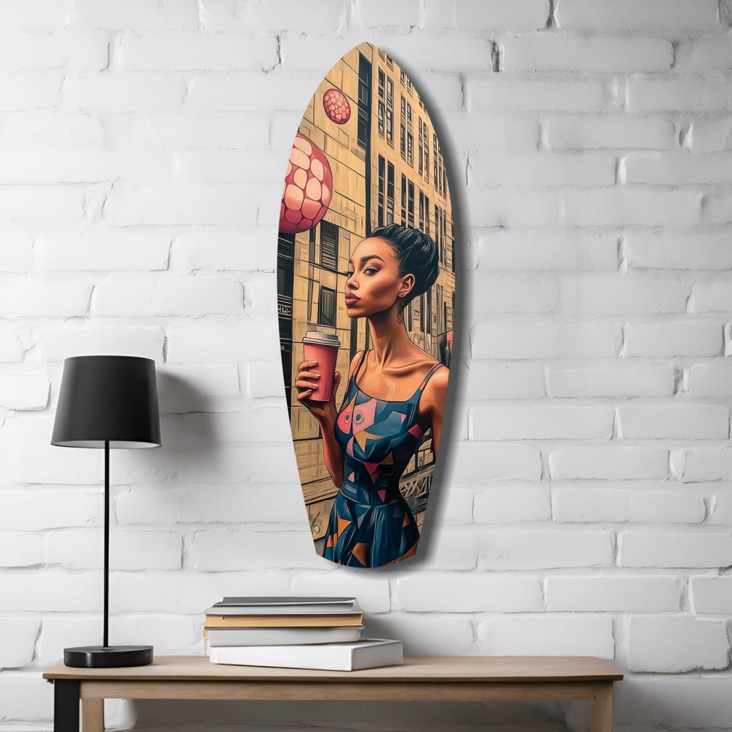 Oval glass wall art depicting a woman in colorful geometric dress holding a drink, mounted on white brick above wooden desk with lamp and books.