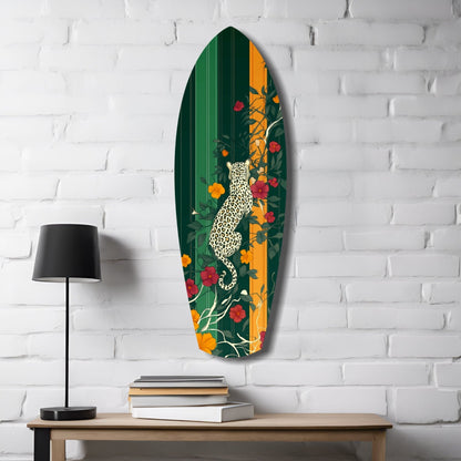 Oval glass wall art displaying a spotted leopard climbing among colorful flowers on green and gold striped background, mounted above wooden desk with lamp and books.
