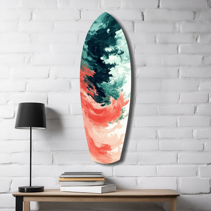 Elongated teardrop-shaped glass art with teal, cream, and coral abstract brushstrokes mounted on white brick wall beside wooden table with lamp and books.