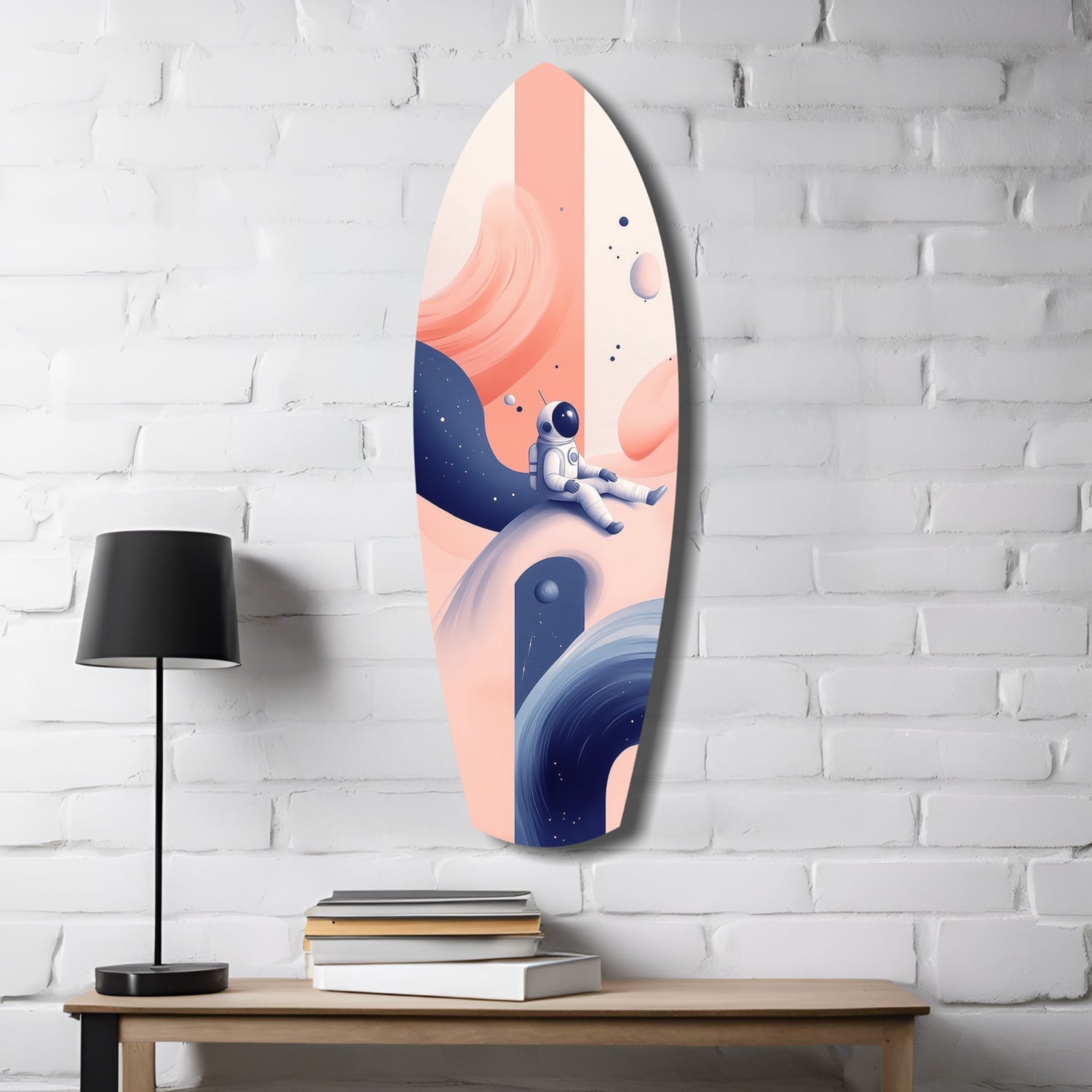 Oval glass wall art featuring an astronaut on a planetary landscape in coral, cream, and navy blue tones, displayed on a white brick wall above a wooden desk with lamp and books.