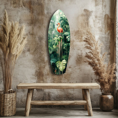 Elongated oval glass wall art depicting a red flamingo among green tropical foliage, displayed above a wooden bench in a rustic interior setting.