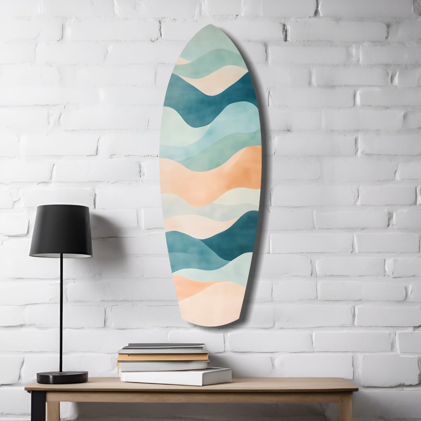 Oval sea glass wall art with layered wavy bands in teal, cream, and peach hung above wooden table with black lamp and stacked books.