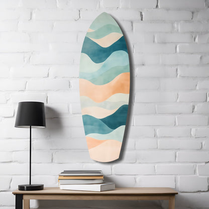 Oval sea glass wall art with layered wavy bands in teal, cream, and peach hung above wooden table with black lamp and stacked books.