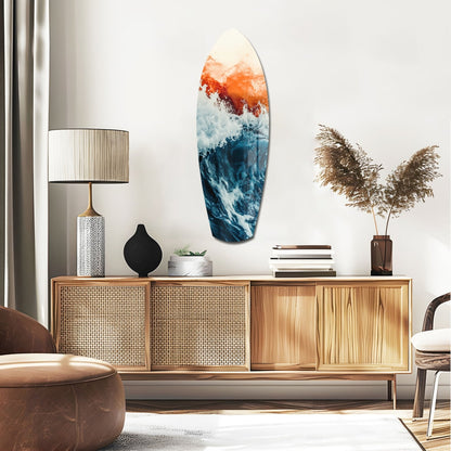 Surfboard-shaped glass wall art with orange sunset gradient transitioning to blue ocean waves, displayed above wooden mid-century credenza in modern living room setting.