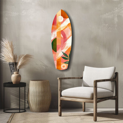 Colorful glass surfboard wall art with orange, red, coral, and green geometric patterns displayed above wooden chair in modern interior setting.