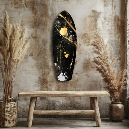 Black and gold abstract wall art mounted above wooden bench in rustic interior with dried grasses and textured wall.