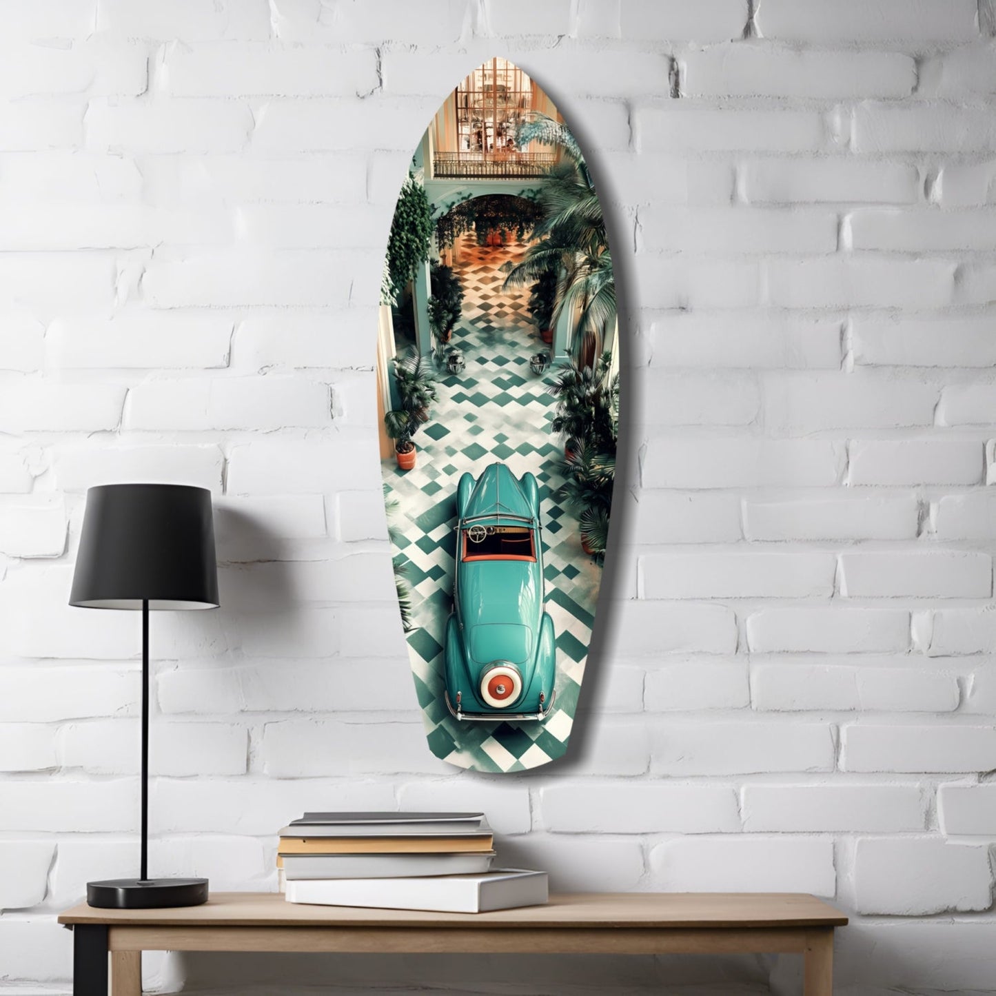 Turquoise vintage car surfboard-shaped glass wall art displayed on white brick beside wooden desk with black lamp and stacked books.