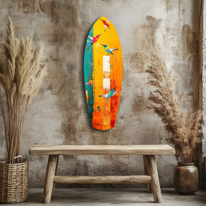 Colorful glass wall art featuring painted birds in yellow, orange, teal, and red tones displayed above a wooden bench against a textured concrete wall.