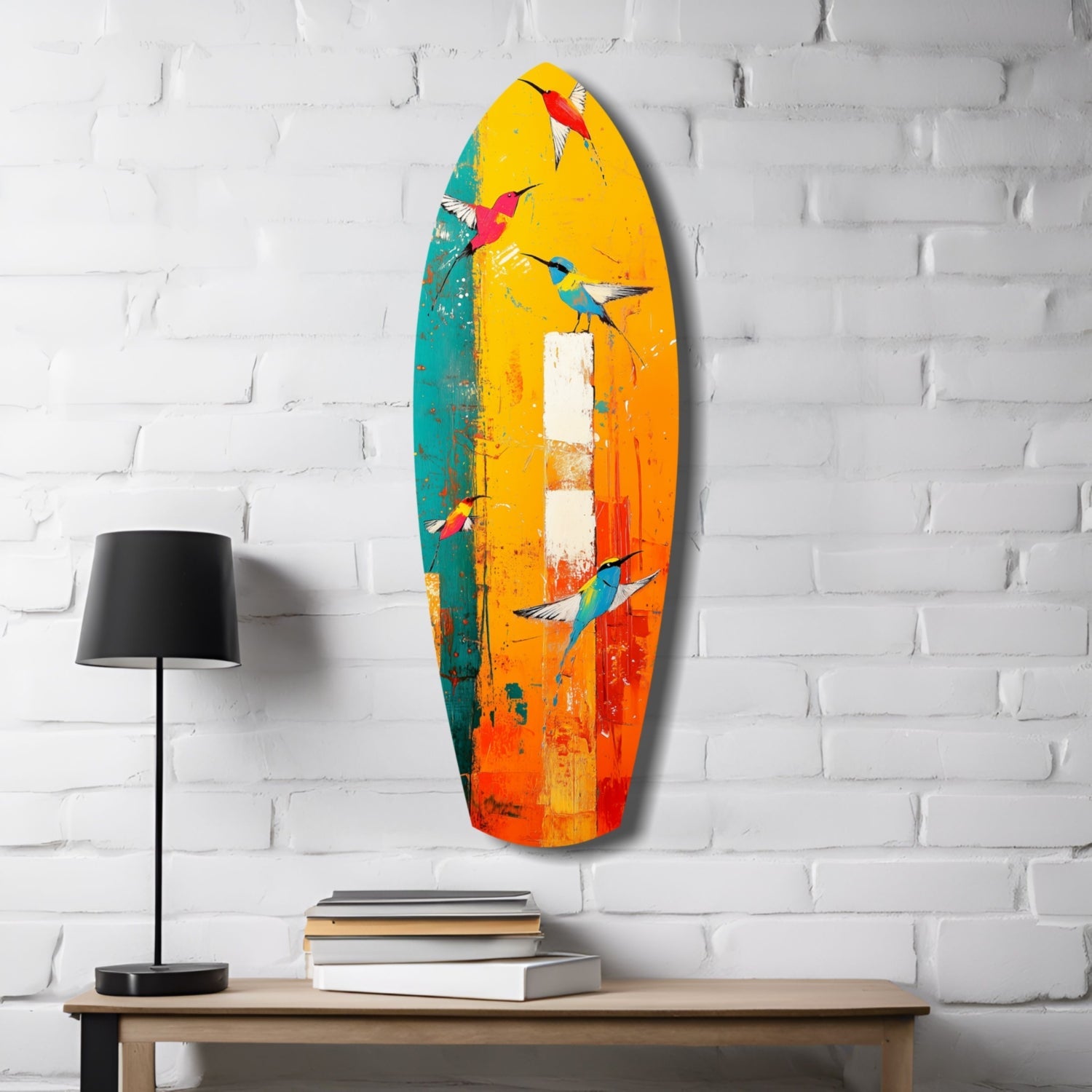 Colorful glass surfboard wall art featuring painted hummingbirds in yellow, orange, teal, and red tones, displayed above a wooden shelf with lamp and books.