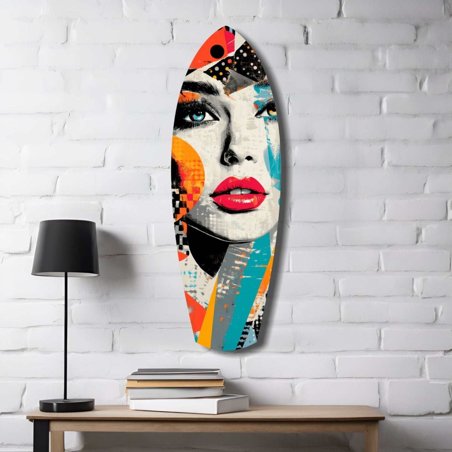 Colorful pop art glass wall hanging featuring a woman's face with red lips and blue eye, displayed on white brick wall above wooden desk with lamp and books.