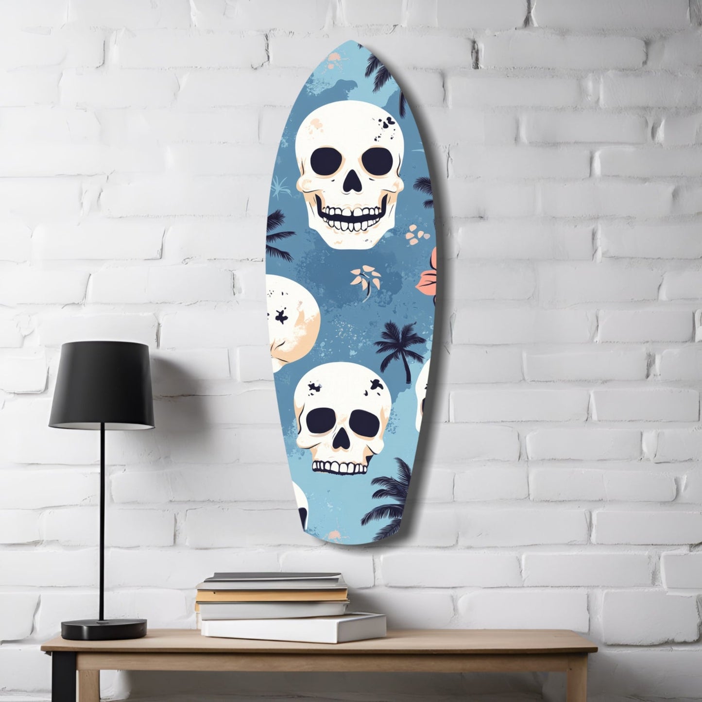 Oval glass wall art with blue background featuring white skulls and tropical palm tree designs, displayed on white brick wall above wooden table with lamp and books.