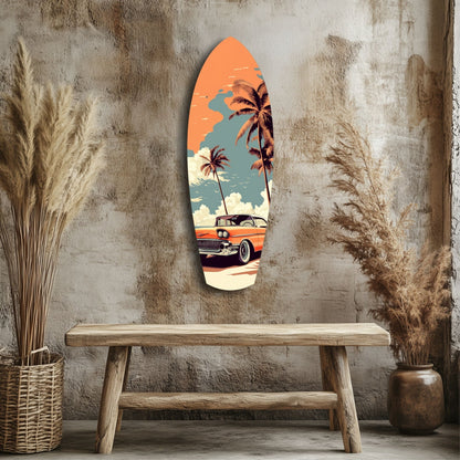 Surfboard-shaped glass wall art hung above wooden bench, featuring orange vintage car, palm trees, and blue sky against textured concrete wall.