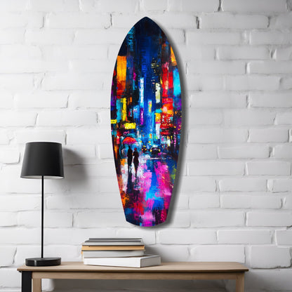Colorful glass surfboard art displaying a vibrant city street scene hangs on white brick wall above wooden desk with lamp and books.