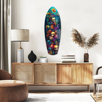 Surfboard-shaped glass wall art featuring colorful underwater coral, tropical fish, and golden skulls displayed above a wooden mid-century credenza in a modern living room.