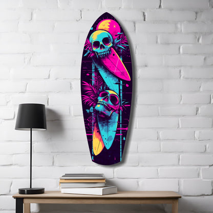 Neon surfboard-shaped glass wall art with colorful skulls and tropical foliage displayed on white brick wall beside lamp and books.