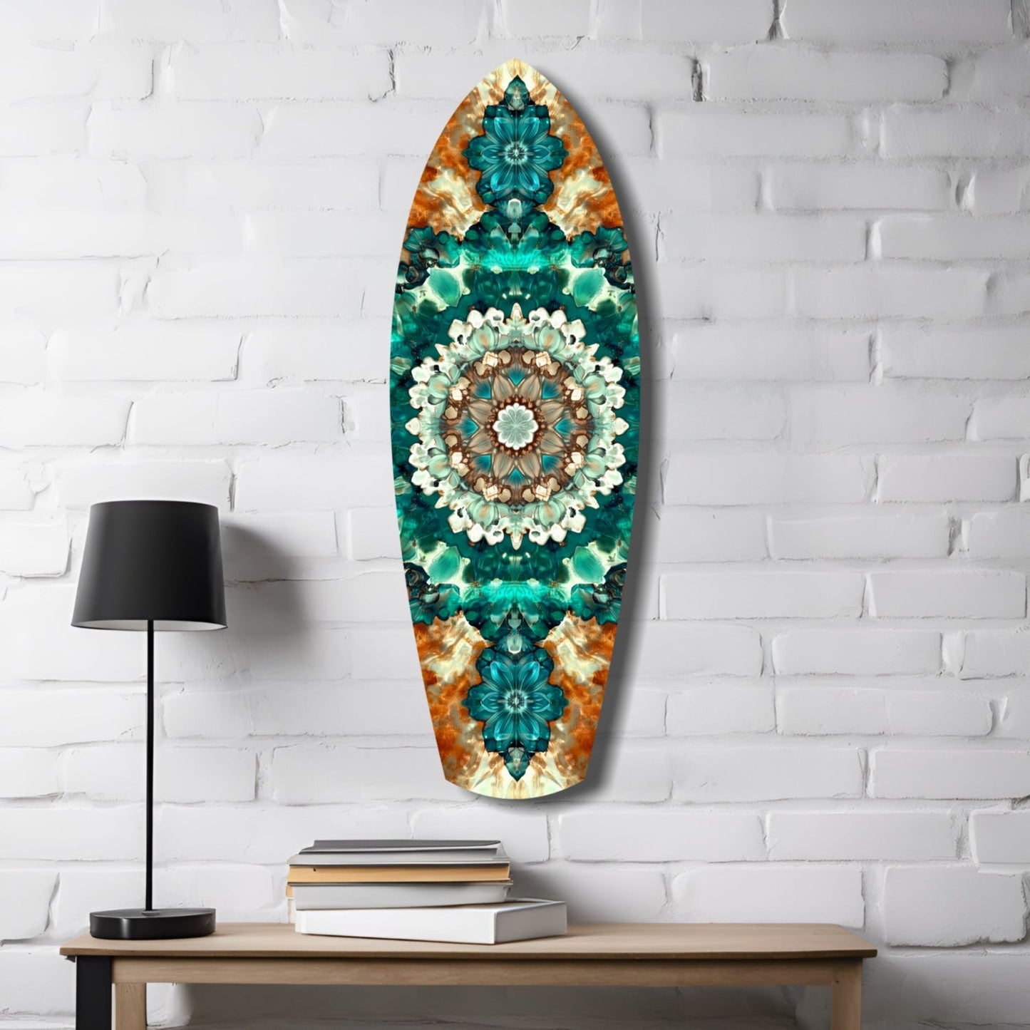 Oval glass wall art with teal, emerald, and orange kaleidoscopic floral design displayed above wooden desk with lamp and books.