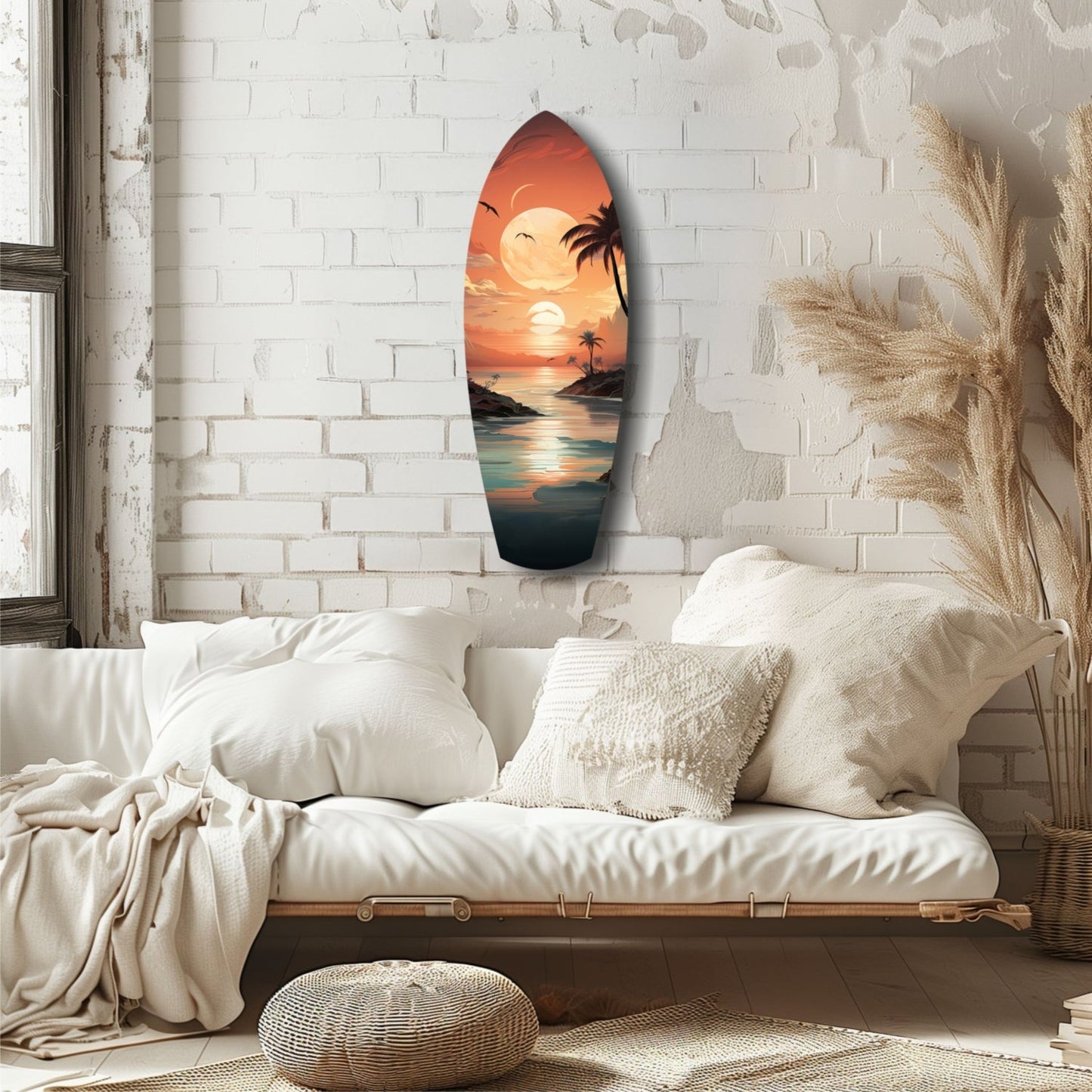 Surfboard-shaped glass wall art depicting a tropical sunset with palm trees and ocean, hung above a white bedside, complemented by cream pillows and dried pampas grass.