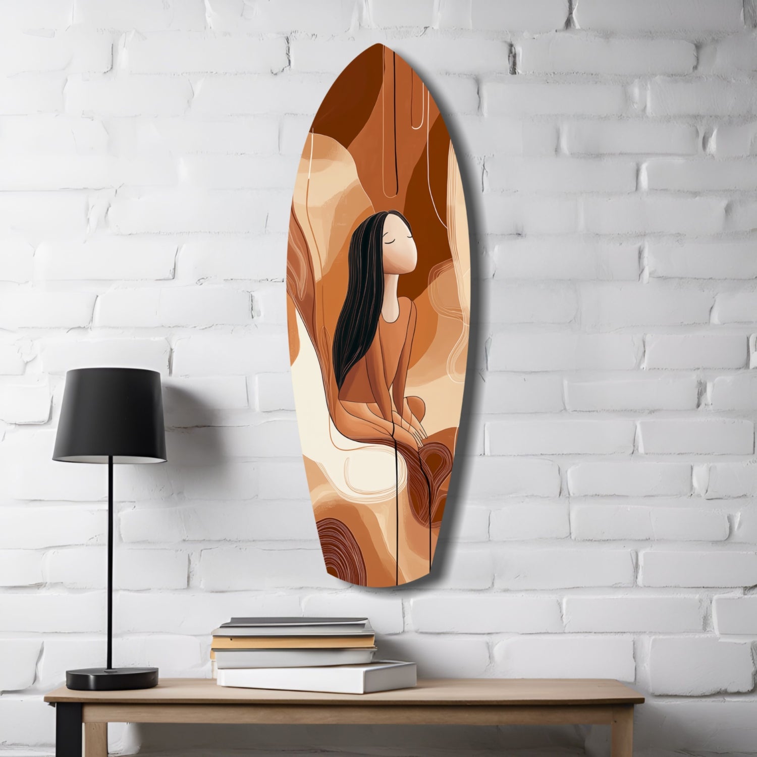 Oval glass wall art featuring a woman with long black hair in warm orange and brown tones, displayed on white brick wall above wooden table with lamp and books.