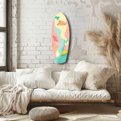 Colorful surfboard-shaped wall art with sea turtles and tropical fish displayed above a cream linen sofa in a bright bedroom.