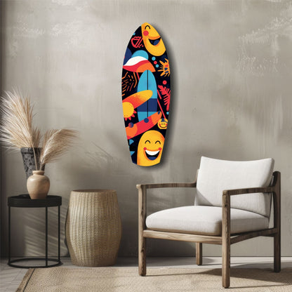 Colorful surfboard-shaped glass wall art with yellow smiling faces, tropical fish, and coral motifs displayed above a wooden chair in a minimalist interior.