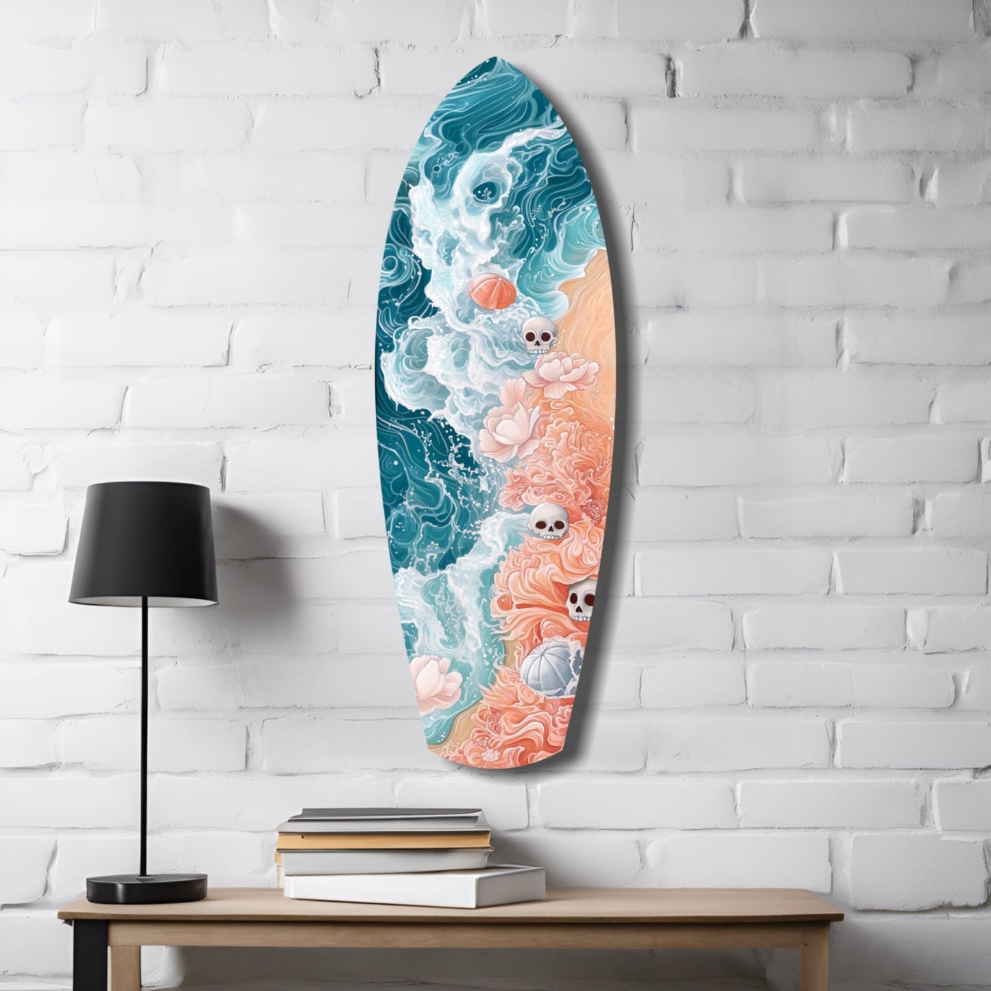 Surfboard-shaped glass wall art featuring teal ocean waves, coral sand, skulls, and flowers, displayed on white brick wall above wooden table with lamp and books.