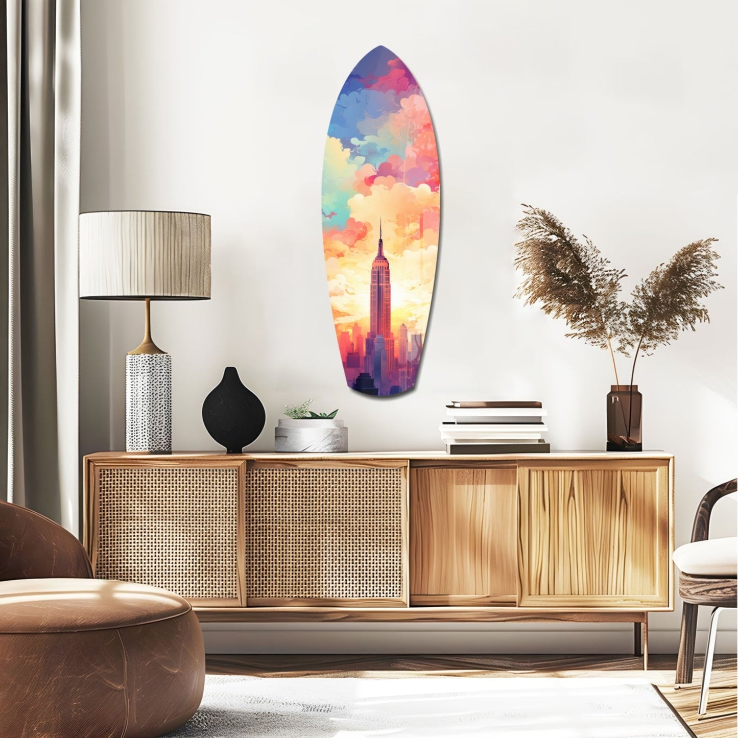 Colorful surfboard-shaped glass wall art depicting Empire State Building silhouette against vibrant rainbow sky, displayed above mid-century wooden credenza in modern living room.